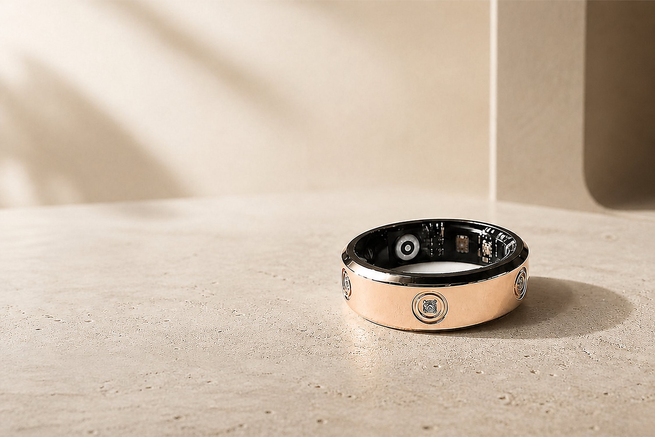 LuxenX Smart Ring in rose gold on a stone surface